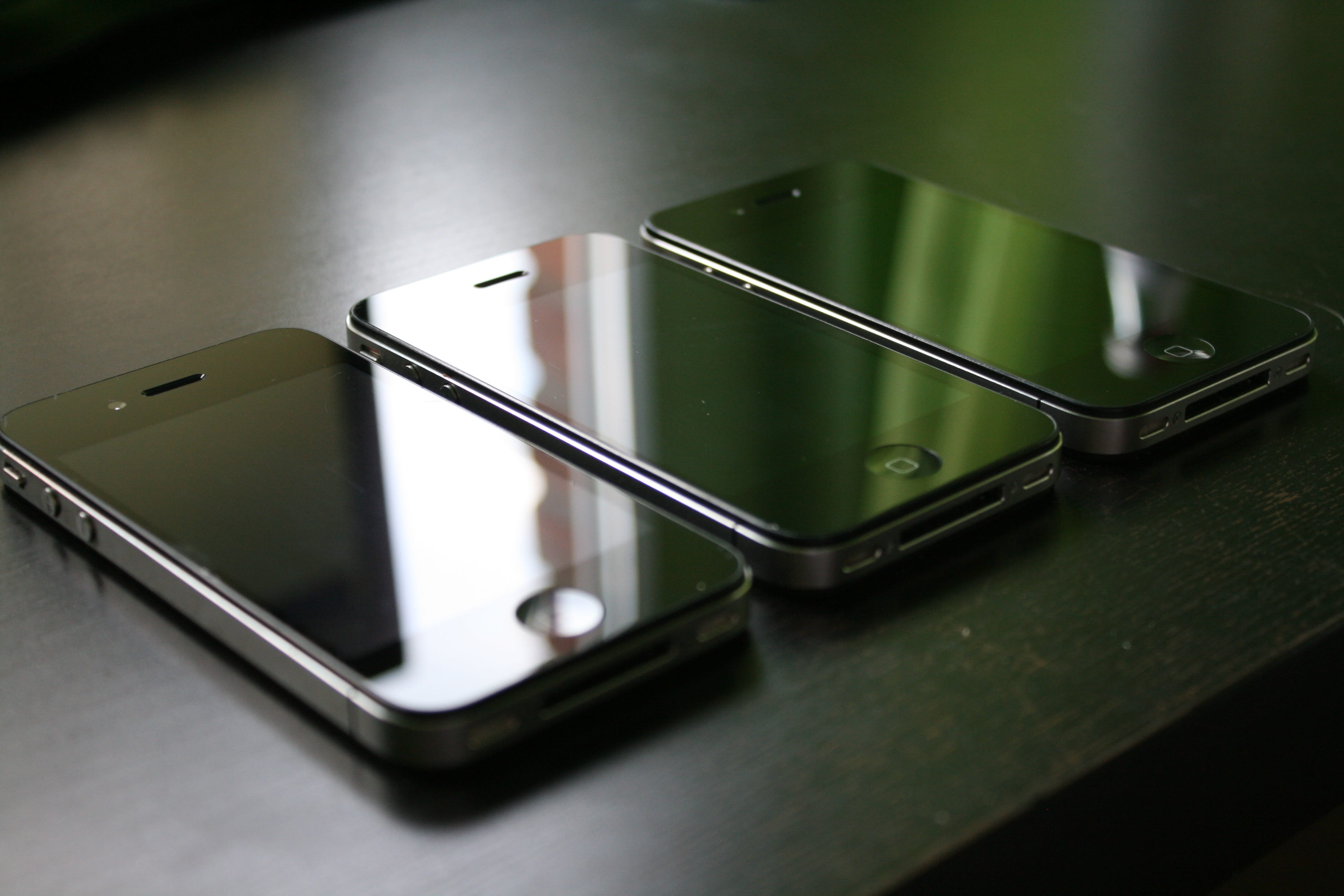 three black iPhone 4's on black surface, smartphone, mobile phone