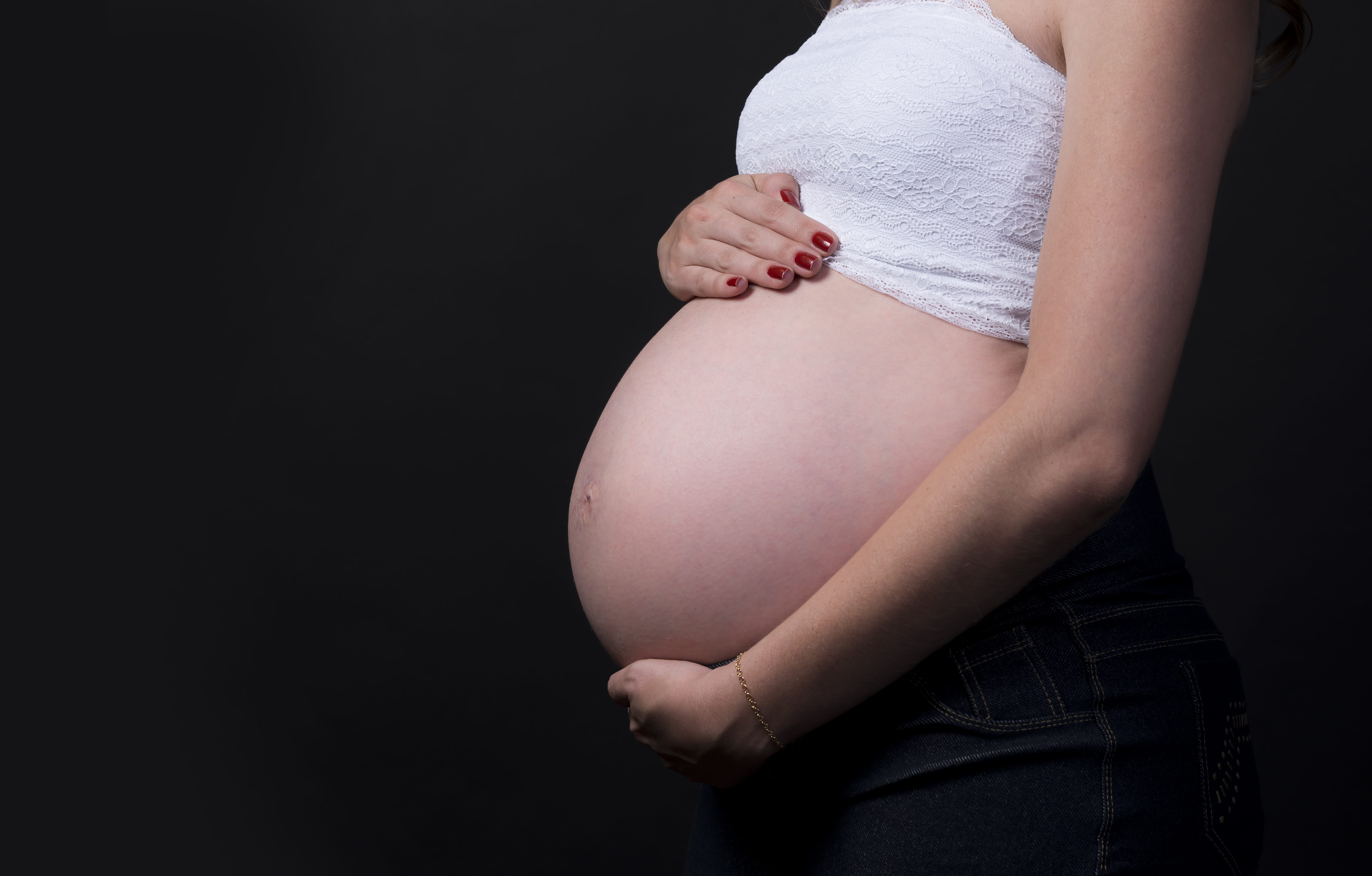 closeup photo of a pregnant woman holding her tummy, mother, pregnancy