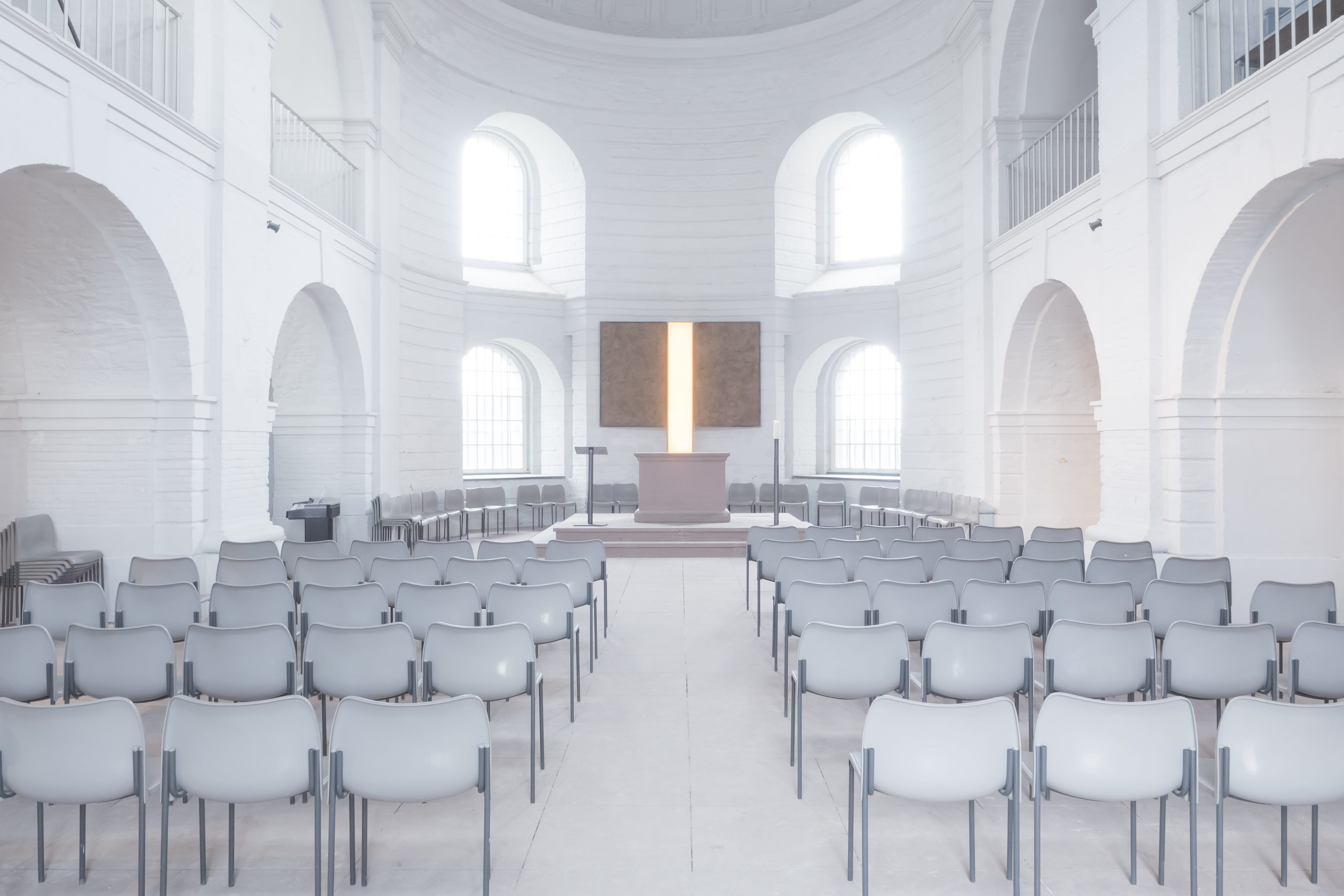 photography of white chairs in white concrete chapel, church