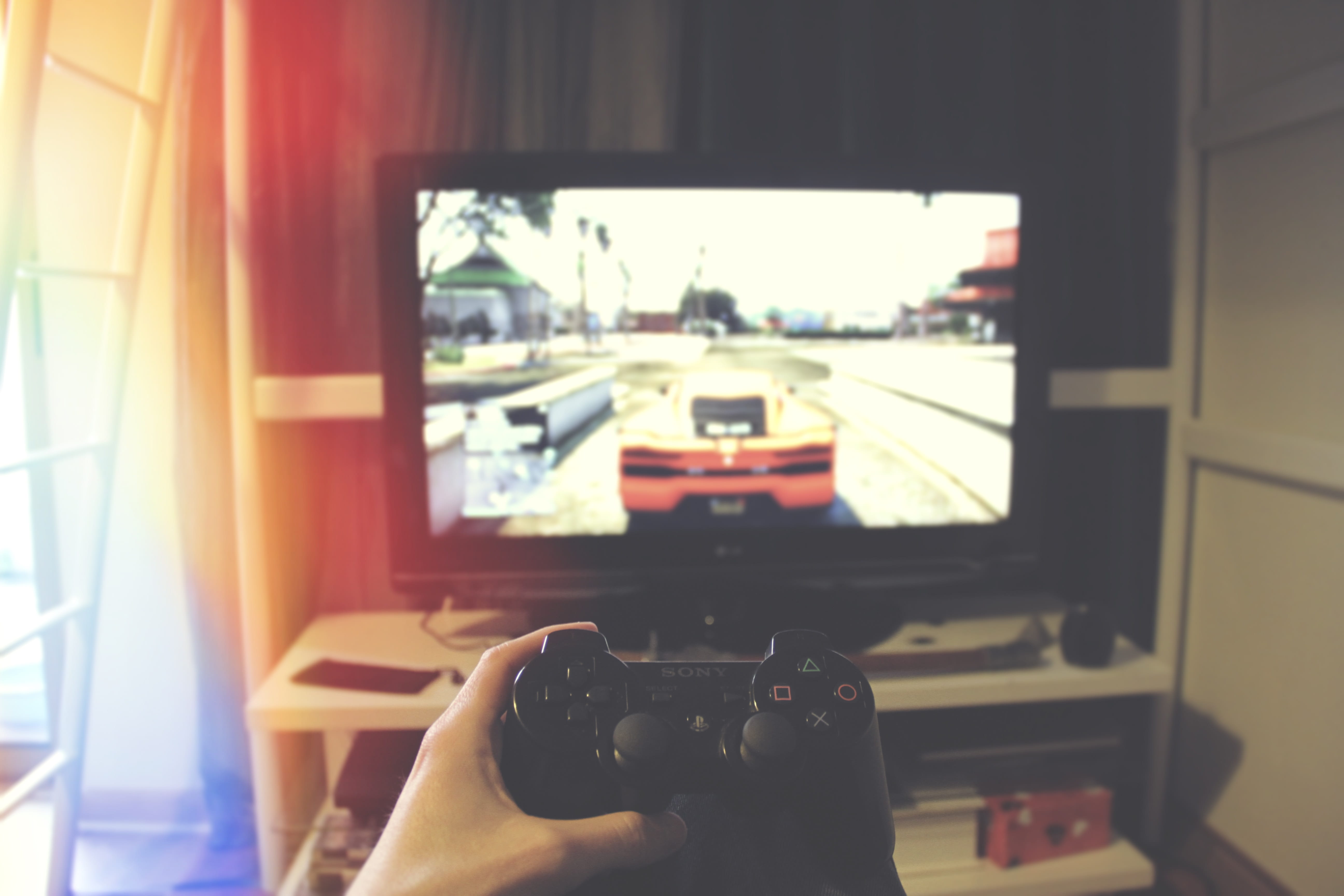 person playing Sony PS3, computer, console, controller, game