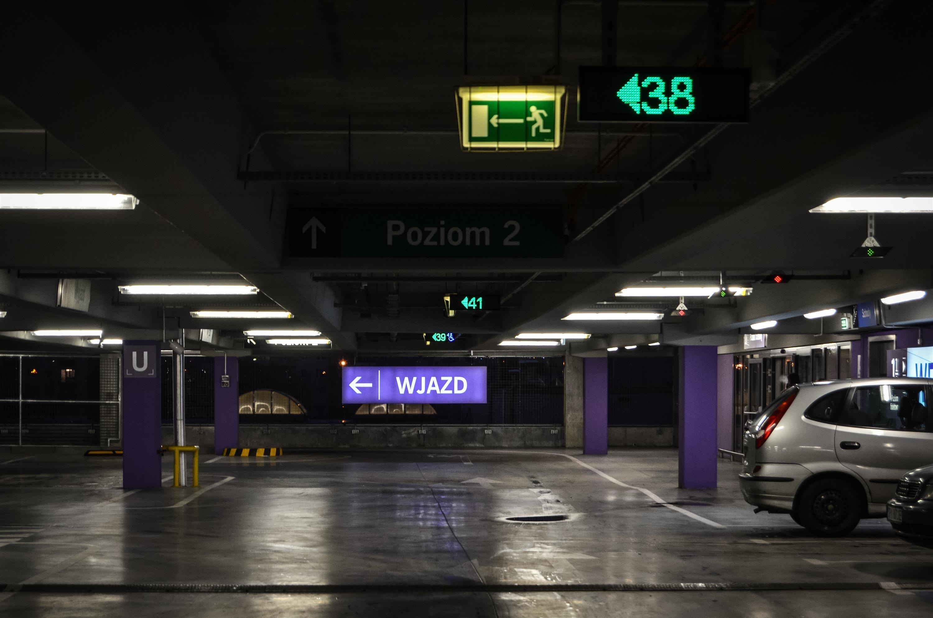 vehicle parked in parking lot building, underground parking, sign