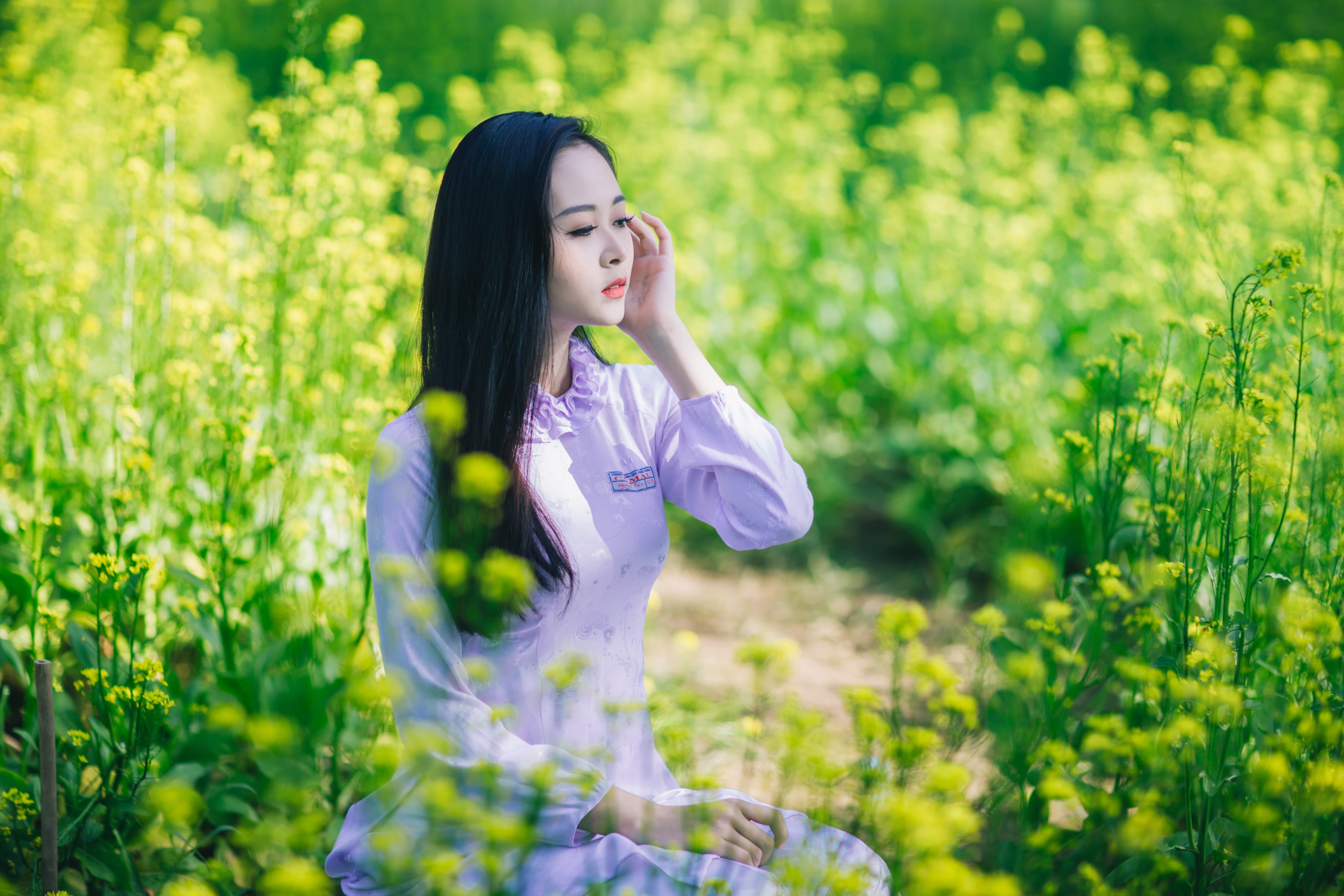 woman wearing gray long-sleeved shirt between grass, girl, flower