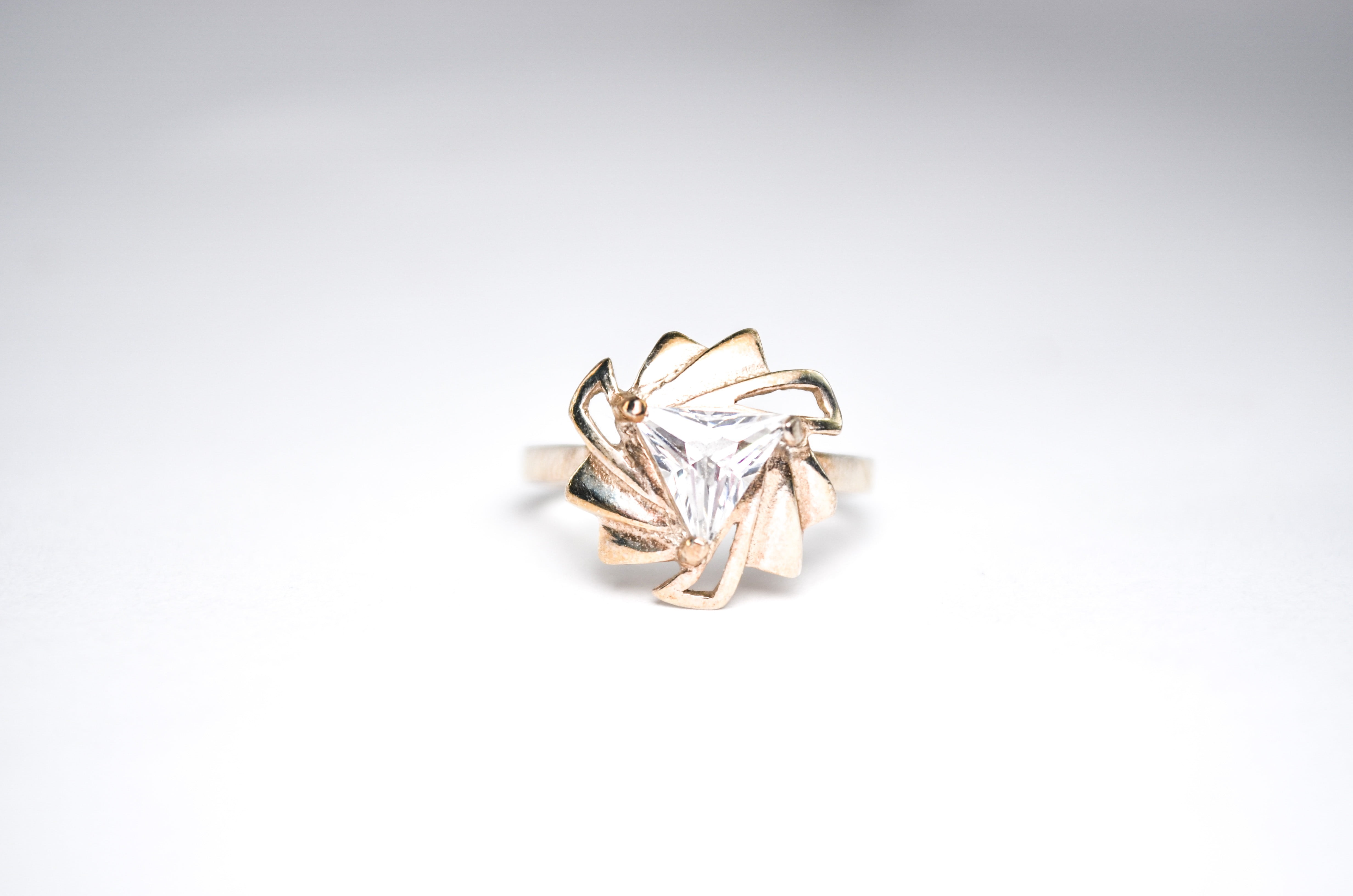 gold-colored clear gemstone encrusted ring on white surface, jewelry