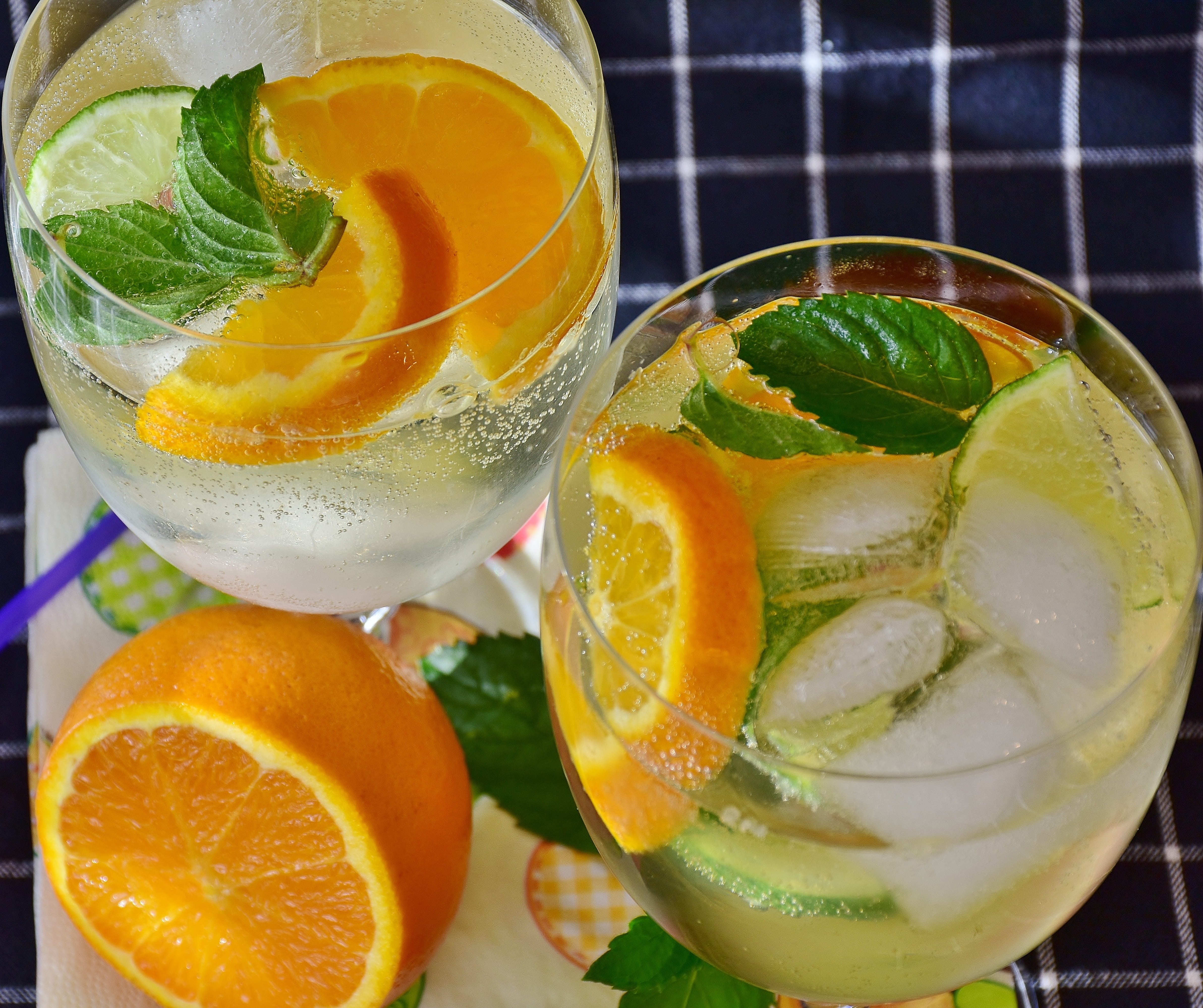 two clear drinking glasses with fruit juices, citrus, waters