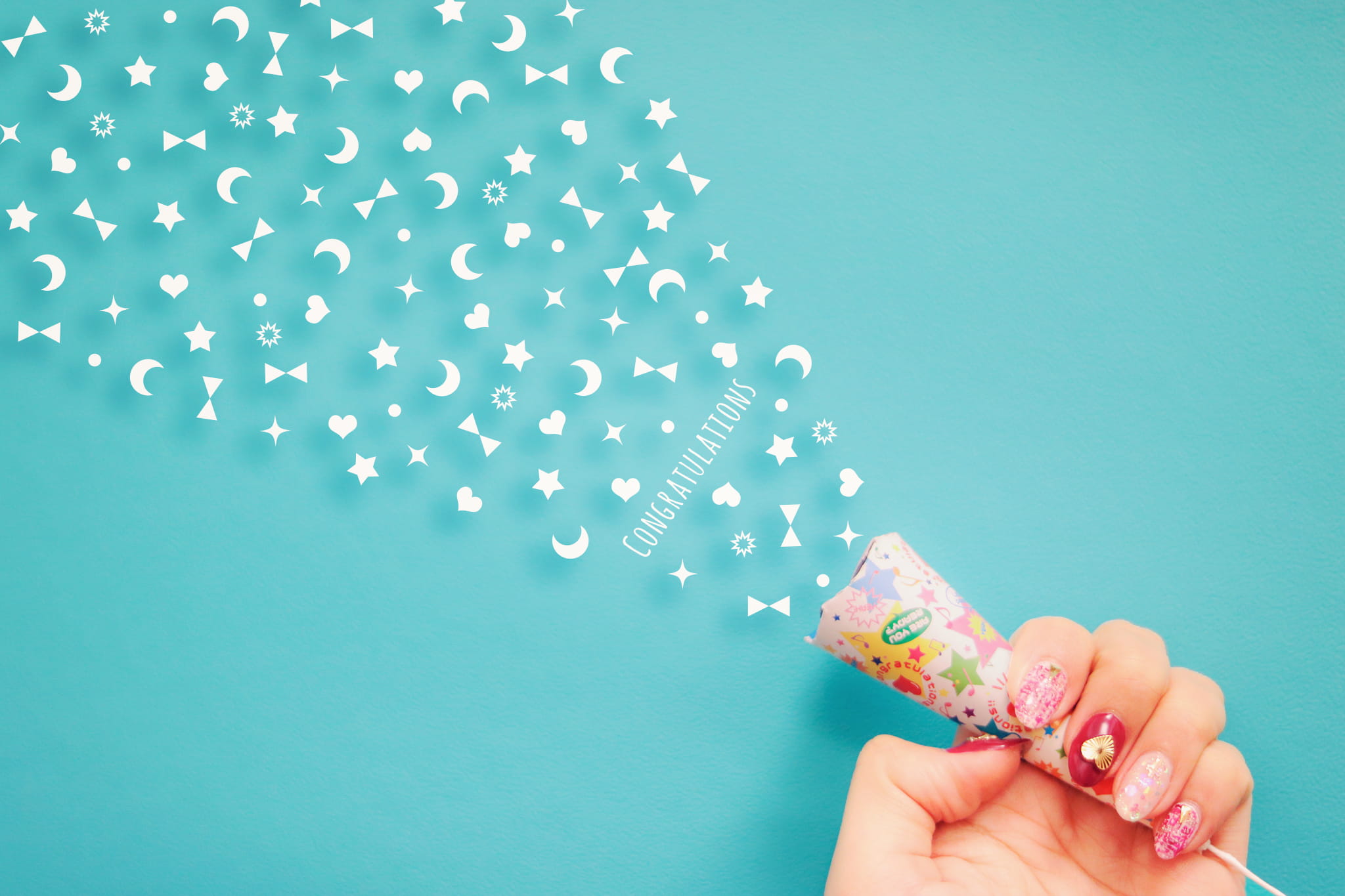person holding white, pink, and blue Congratulations party popper