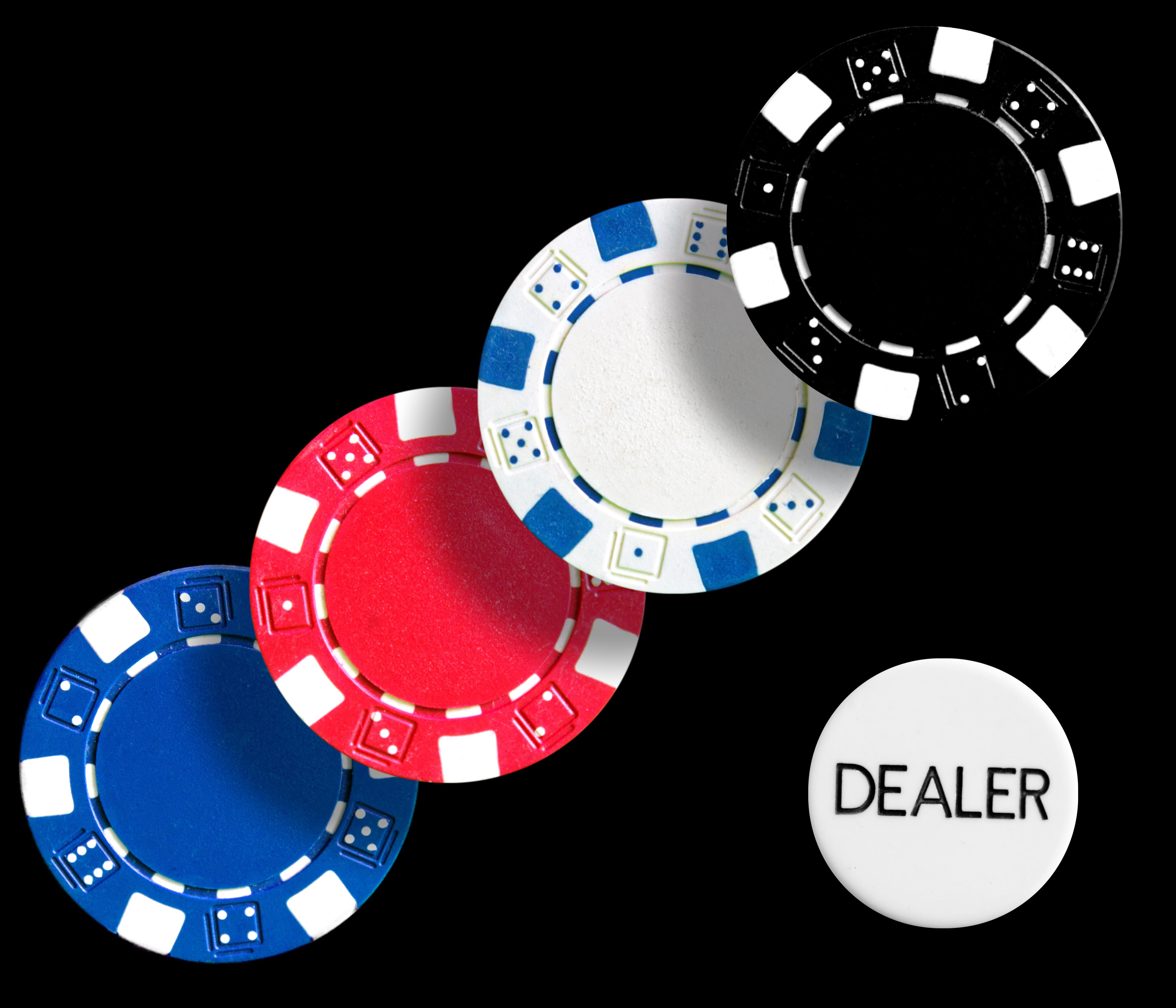 four assorted-color poker chips against black background, play