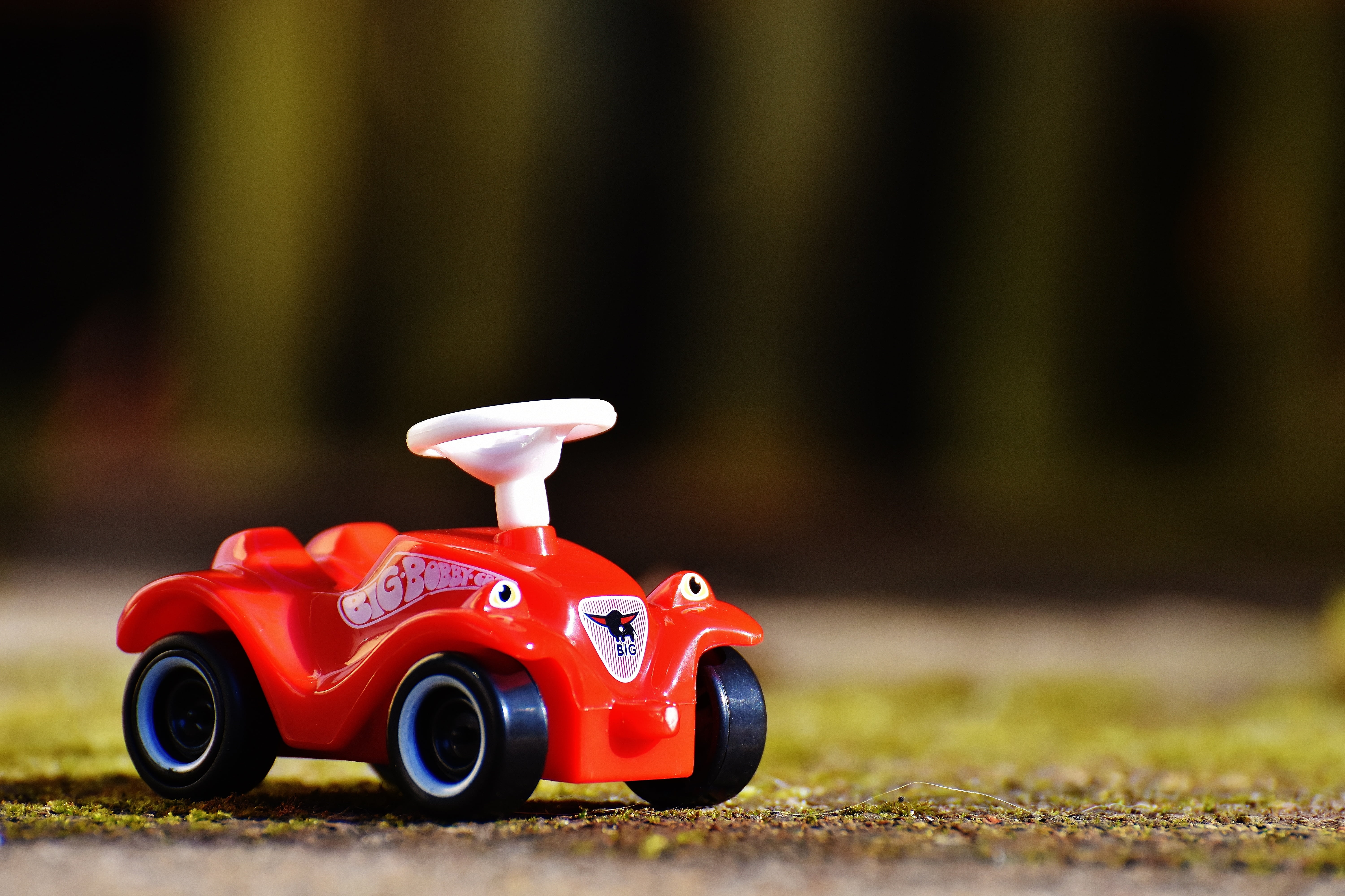 selective-focus photography of red plastic car toy, bobby car
