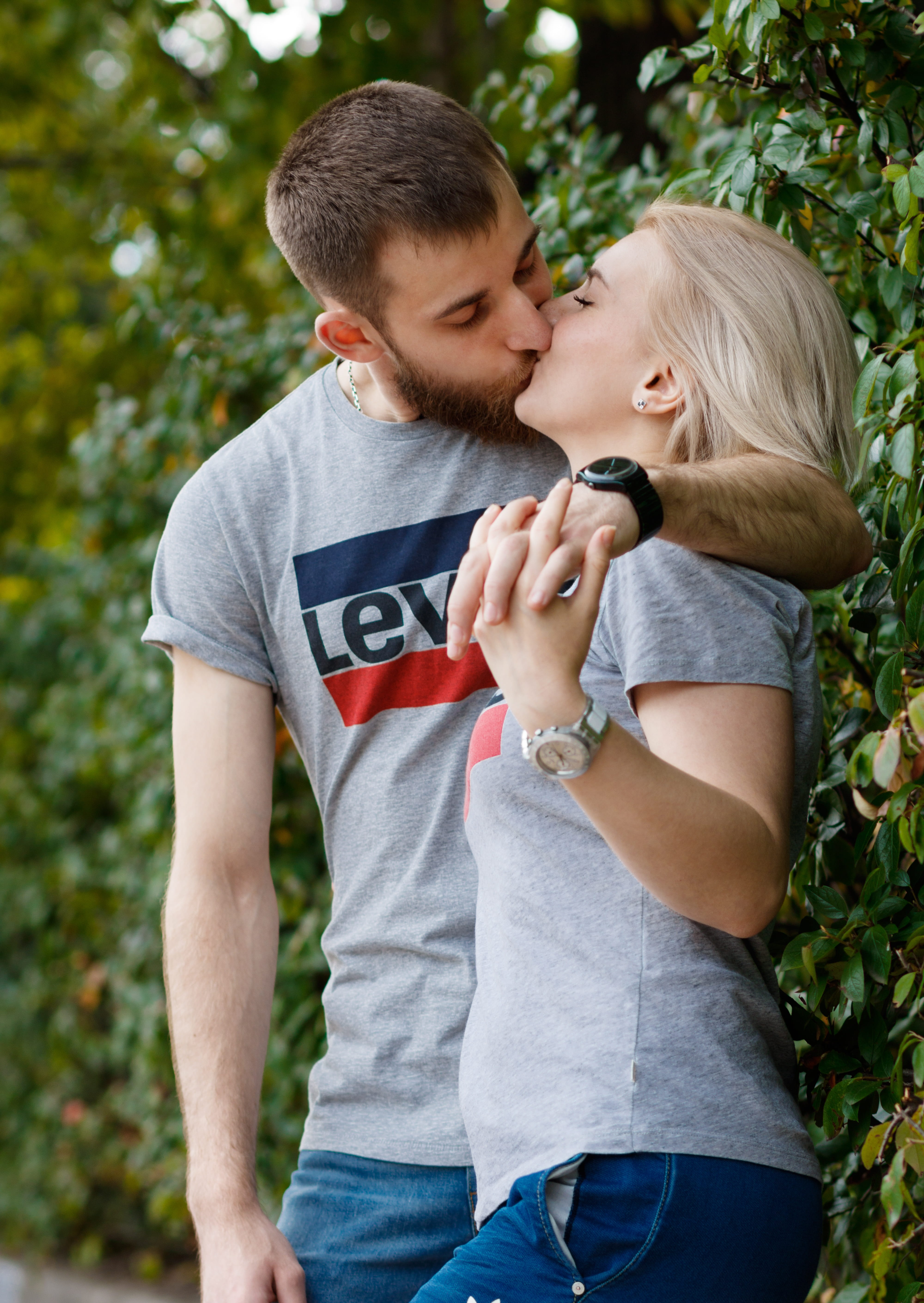 couple kissing beside plant, girl, man, love, young, happy, together