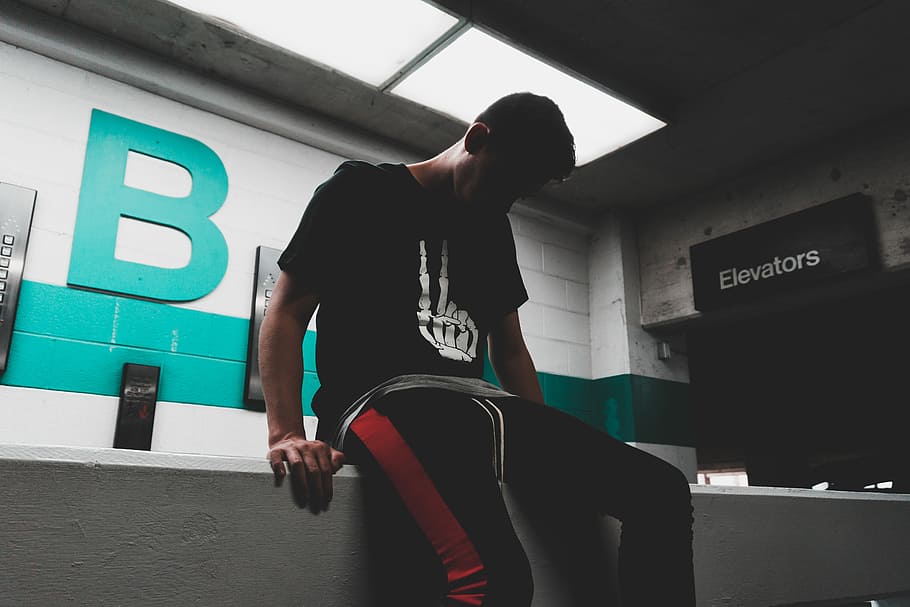 man sitting on concrete desk, man wearing black sweatpants sitting on ledge HD wallpaper