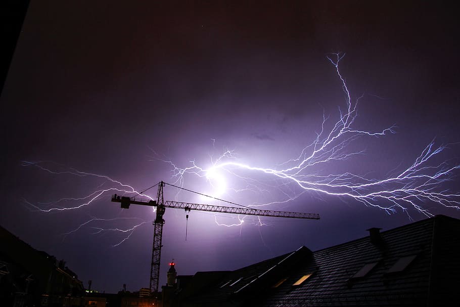 crane on ground with lightning background, thunderstorm, flash
