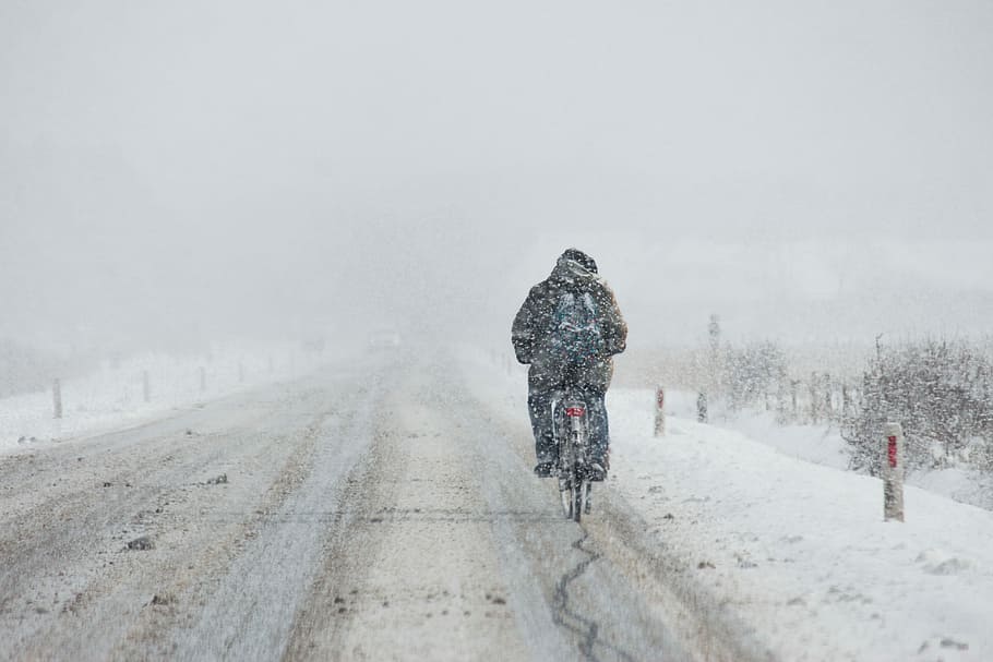 person riding motorcycle on snow coated road, man biking on snow road HD wallpaper
