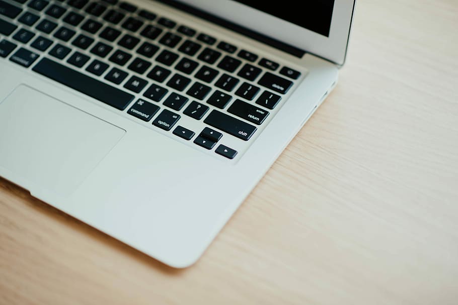 MacBook Air on top of brown wooden furniture, silver MacBook Air turned off HD wallpaper