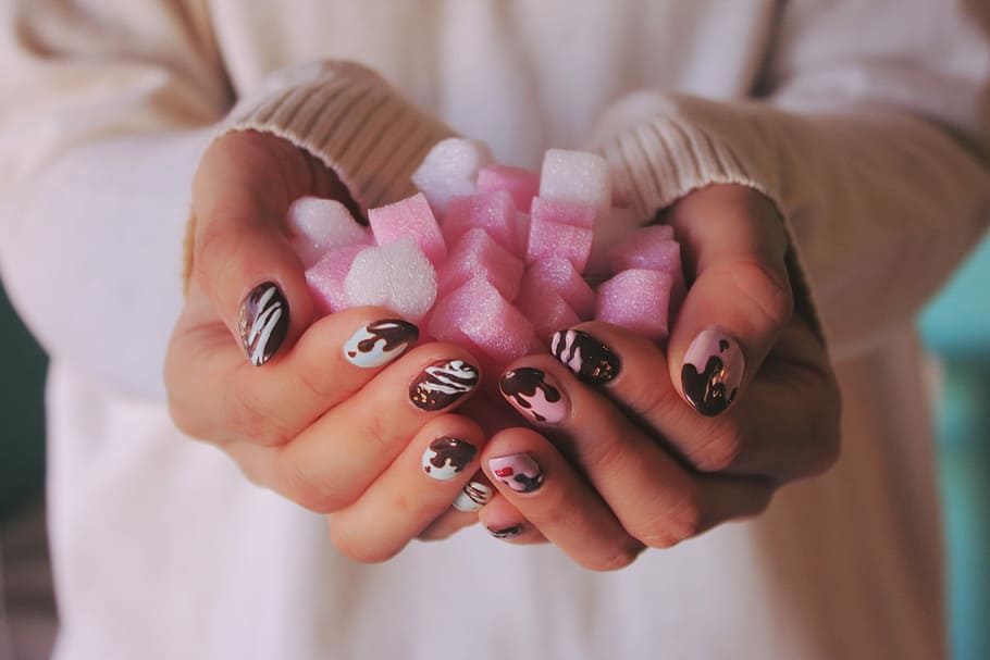 person in white sweater holding pink and white ornaments, human Hand HD wallpaper