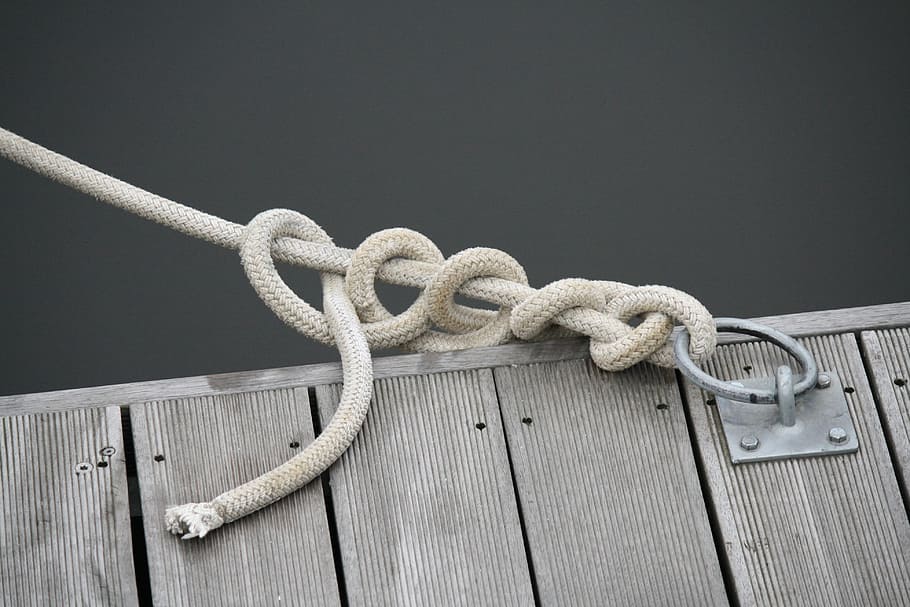 close up photo of white rope tie on buckle, knot, boat, marine