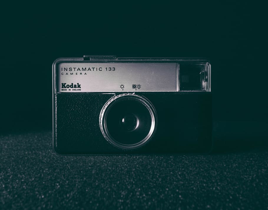 black and white camera on black surface, black and gray Kodak Instamatic 133 camera