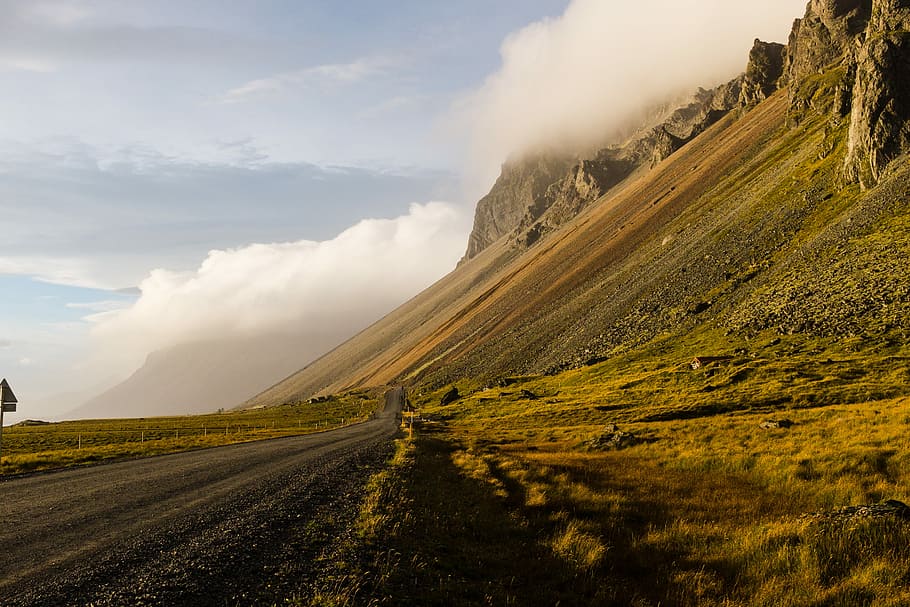 pathway leading to rock formation, roadway near green grass, cliff HD wallpaper