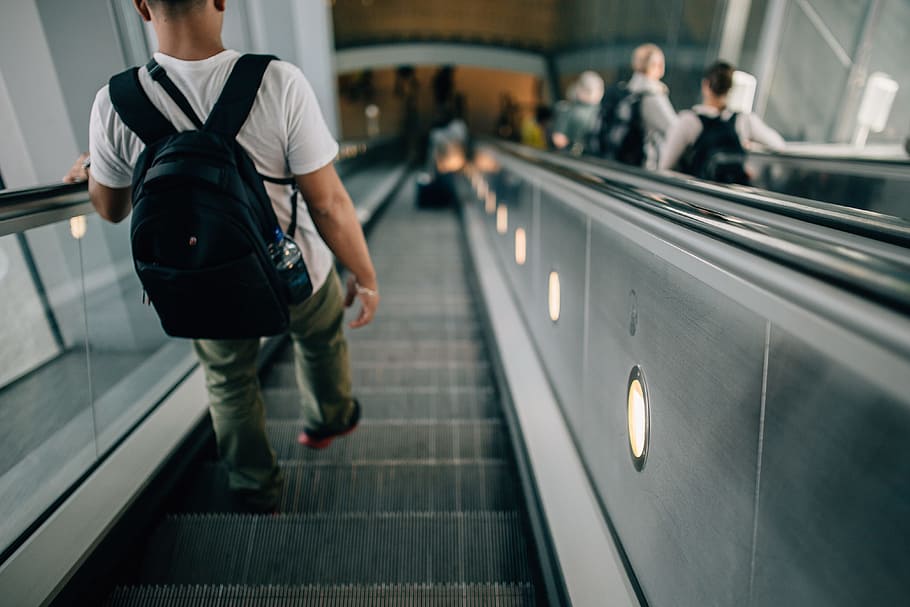 Person Wearing Black Backpack Riding Down the Escalator, boarding HD wallpaper