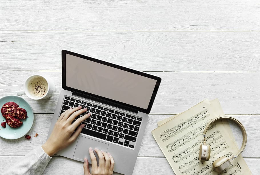 person's hand on laptop keyboard beside cup of coffee, computer HD wallpaper