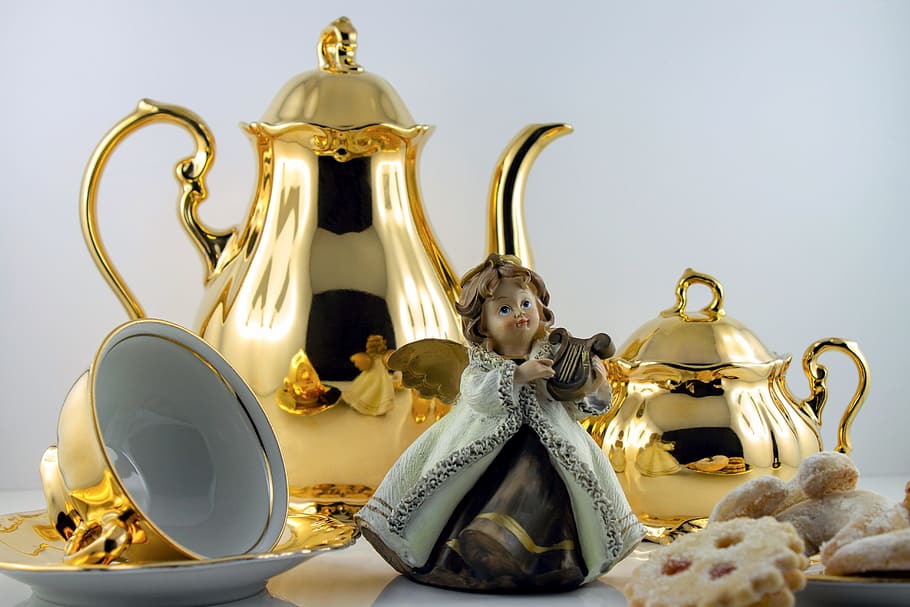 angel playing wind instrument figurine beside gold-colored teapots and teacup, HD wallpaper