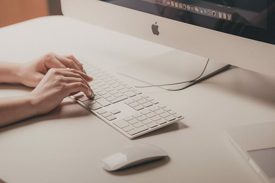 person typing on Apple keyboard, person using Apple Magic keyboard beside Apple Magic Mouse and Imac HD wallpaper
