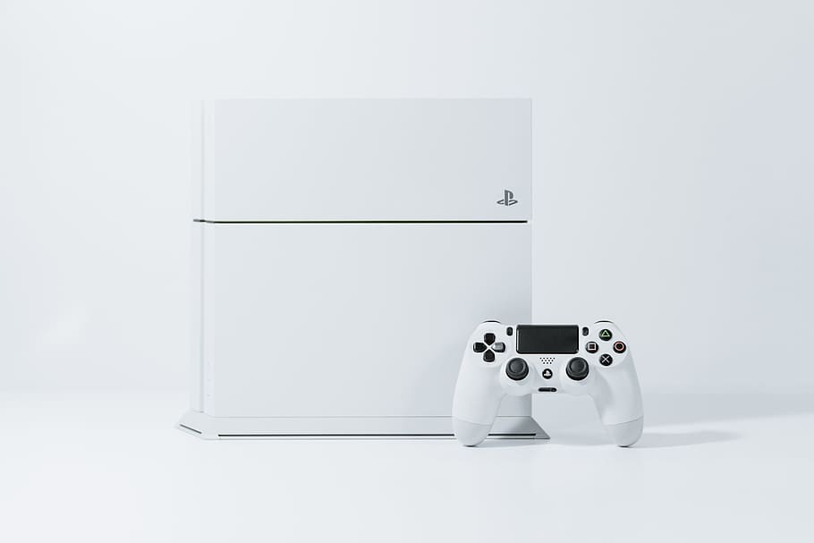 white Sony PS4 Original with controller, white Sony PS4 with controller on white surface