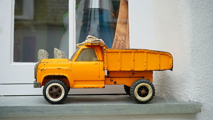 orange dump truck toy placed near glass panel window, vehicle, HD wallpaper