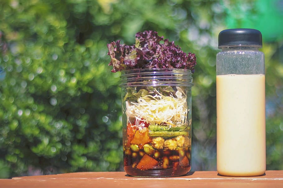clear glass container with sliced vegetable on wooden top surface at daytime HD wallpaper