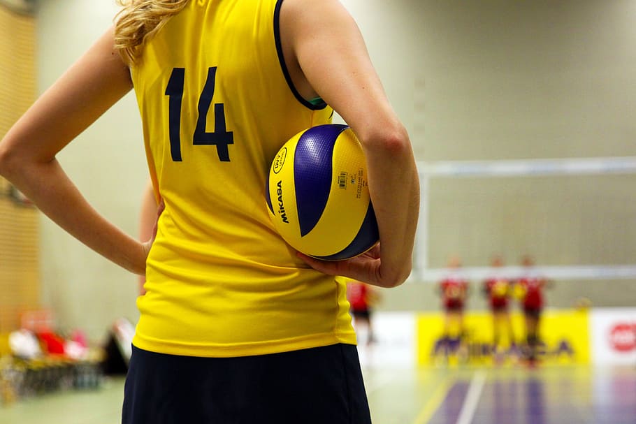 macro shot photography of volleyball player holding ball, woman