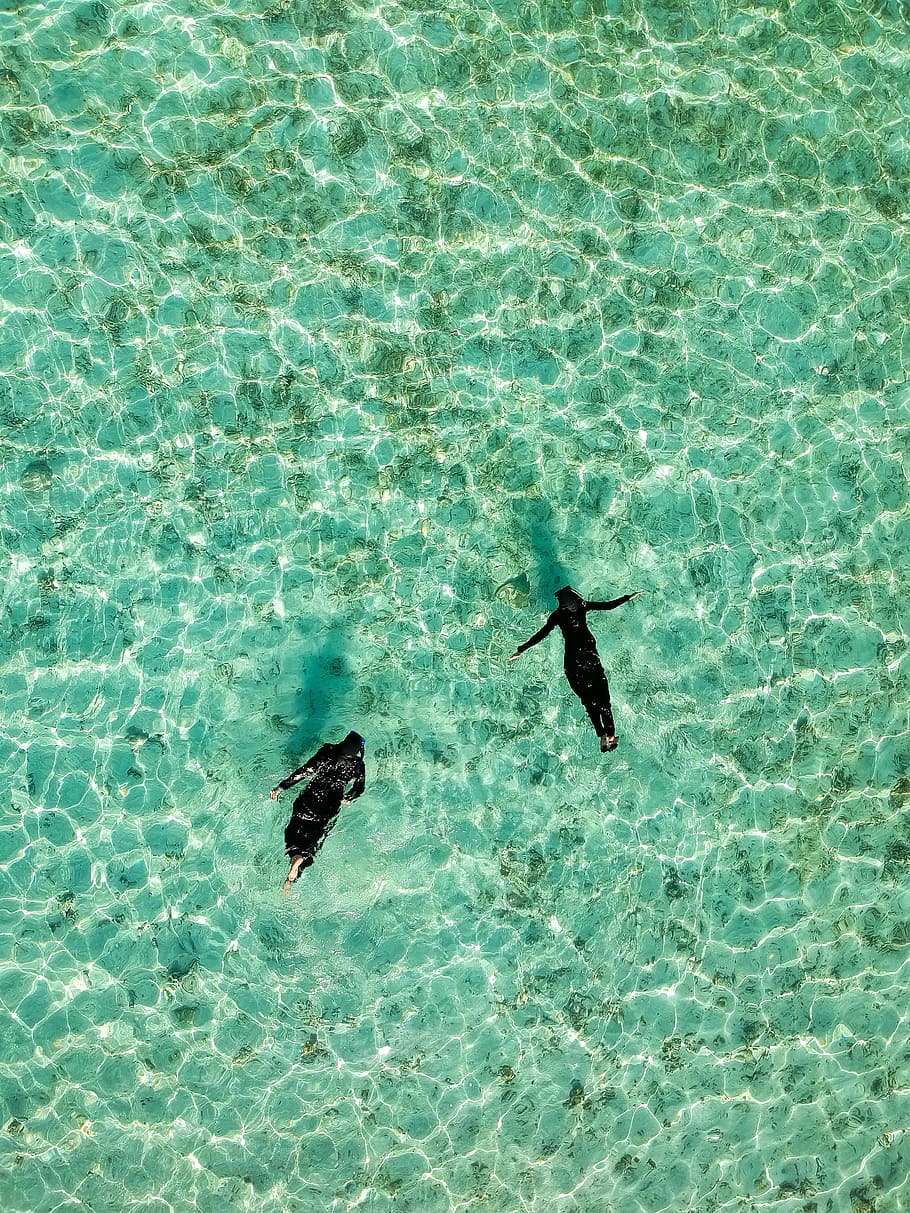 aerial photo of two human swimming on body of water, two person floating on body of water HD wallpaper