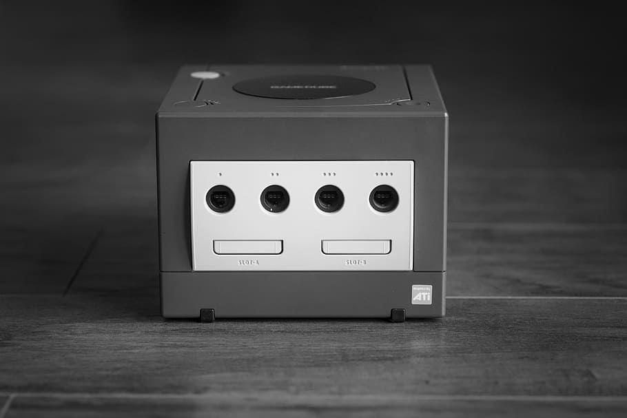 white and black Nintendo GameCube on gray surface, grayscale photography of Nintendo Game Cube