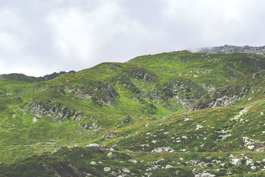 green grass field on mountain under cloudy sky at daytime, low-angle photo of mountain with green grass HD wallpaper