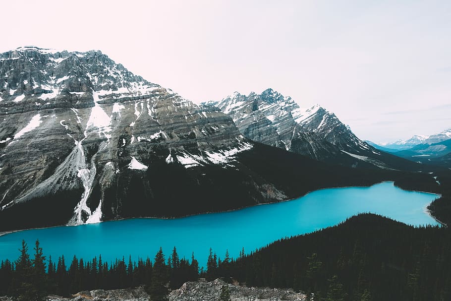body of water across mountain during daytime, lake between mountains and trees during daytime HD wallpaper