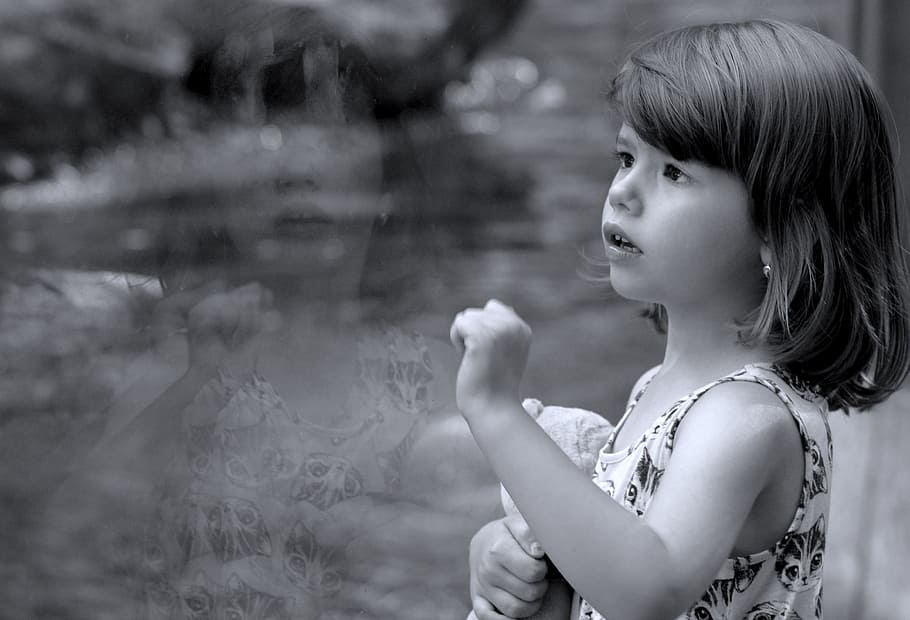 grayscale photo of girl standing next to clear glass panel HD wallpaper