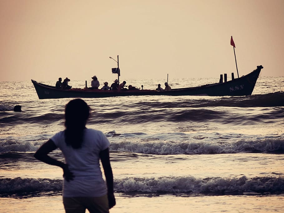 photo of girl looking towards boat on body of water, sea, ocean
