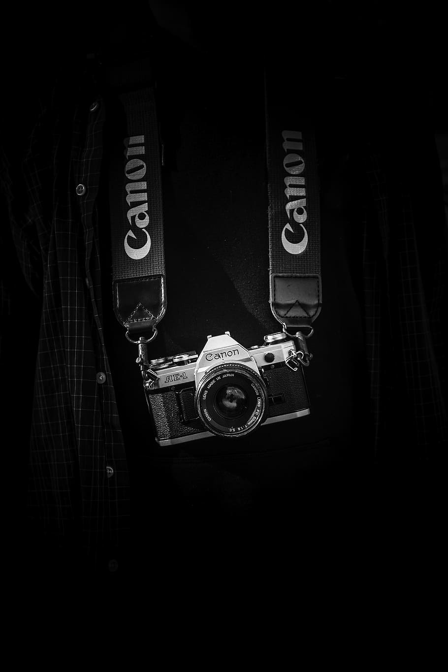 gray and black Canon camera body with lanyard, gray and black Canon camera