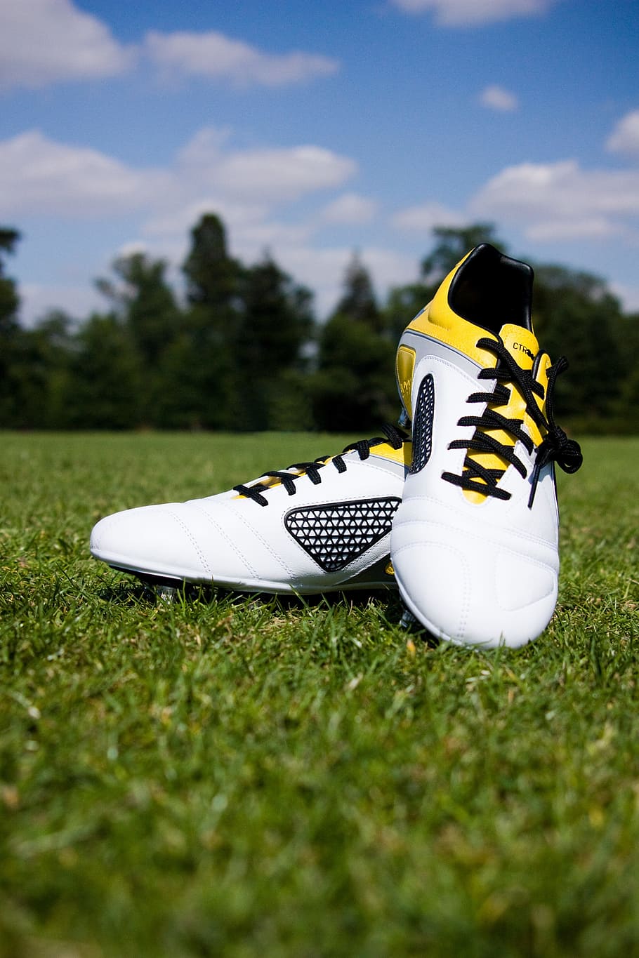 pair of white-and-yellow cleats on green grass, Football, Boots