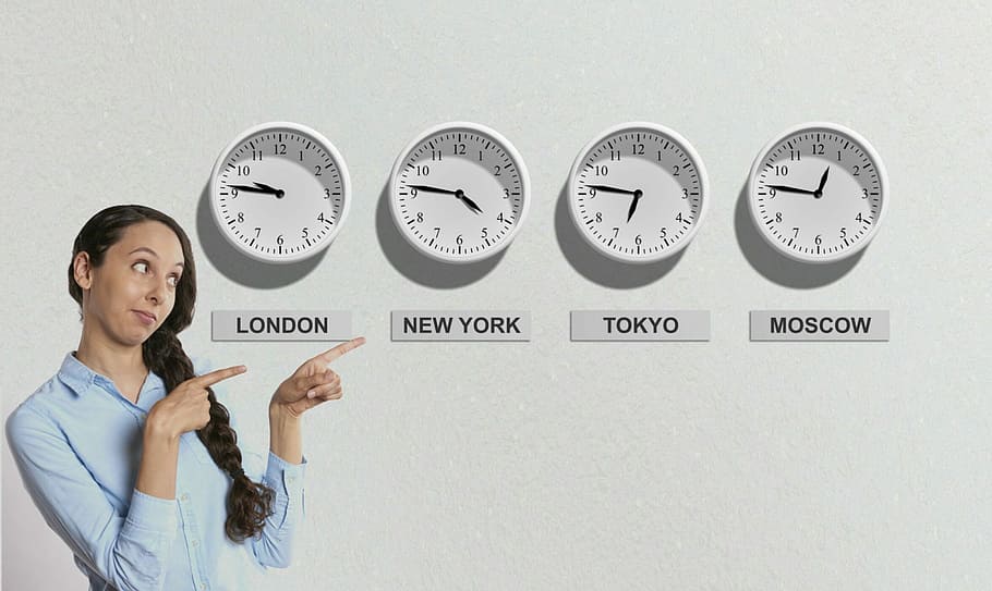 selective focus photography of woman pointing four analog wall clocks HD wallpaper
