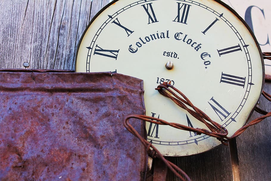 round white Colonial Clock Co. analog clock on brown wooden surface HD wallpaper
