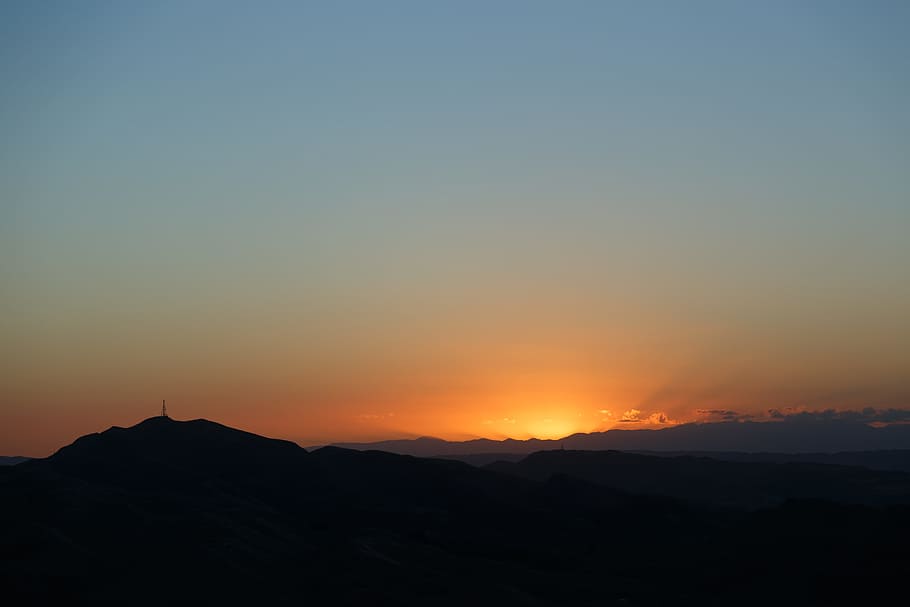 silhouette of mountain against sunrise, sun behind clouds, sunset HD wallpaper