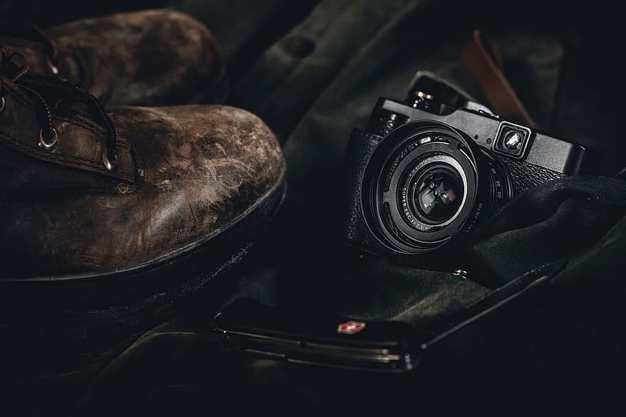 bridge camera beside pair of brown leather round-toe boots, lifestyle