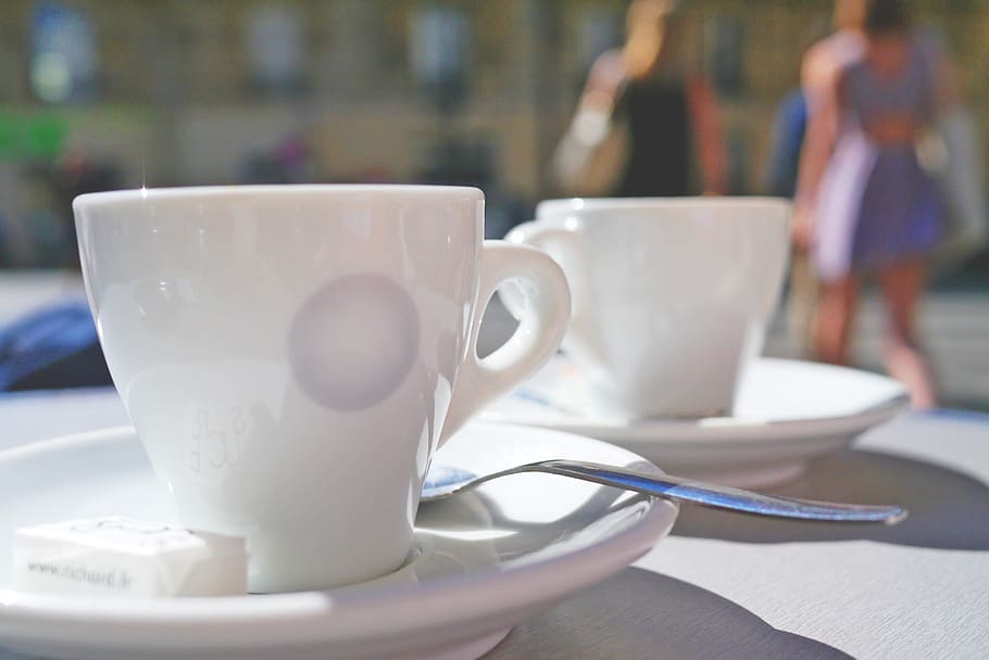 white ceramic cups and saucer on table, espresso, street cafe