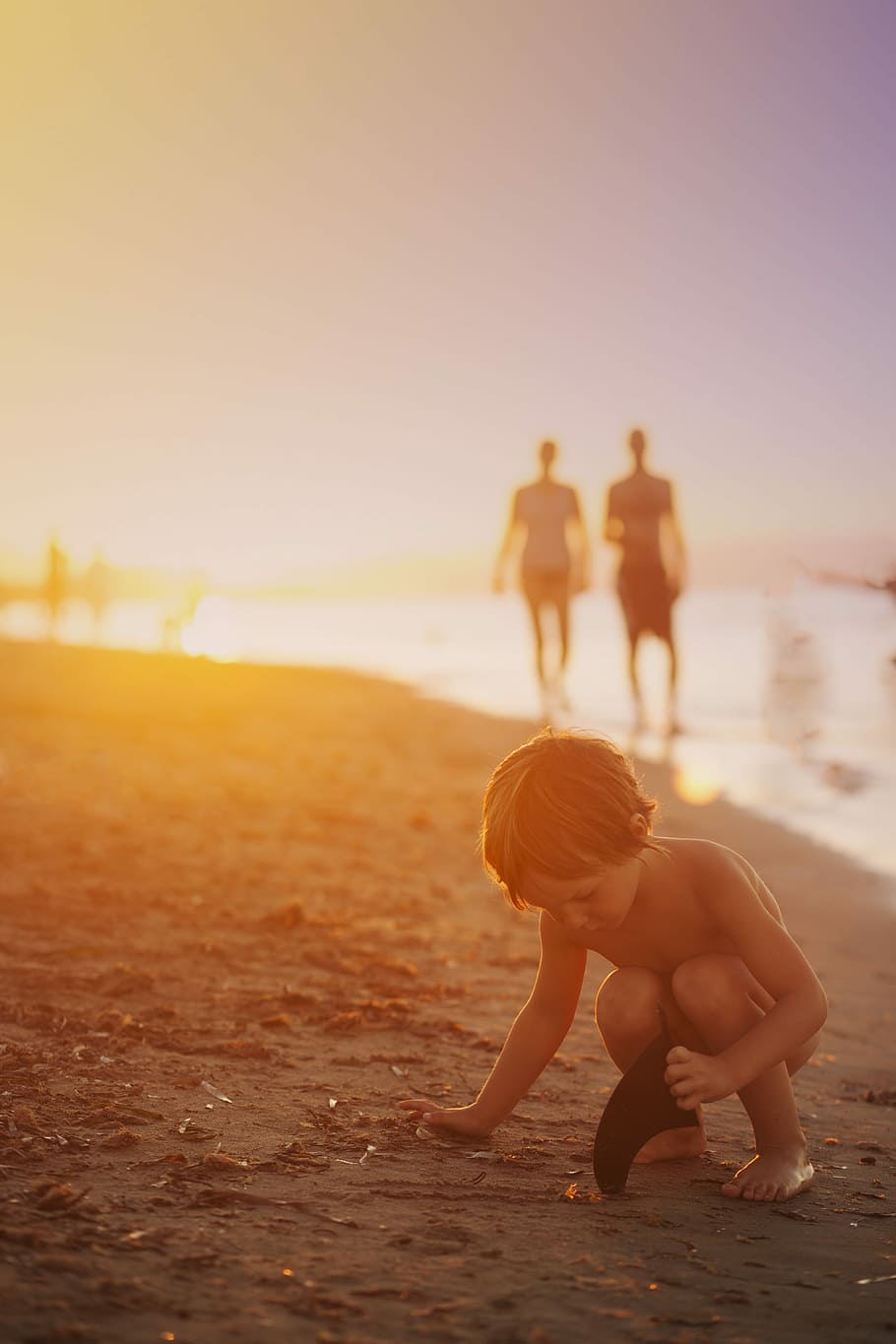 boy playing sand on seashore during sunset, child playing beside seashore HD wallpaper