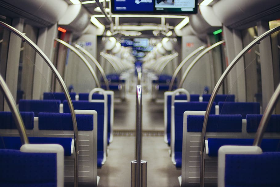 An empty train with blue seats and circular hand rails and monitors, blue and white train chair HD wallpaper