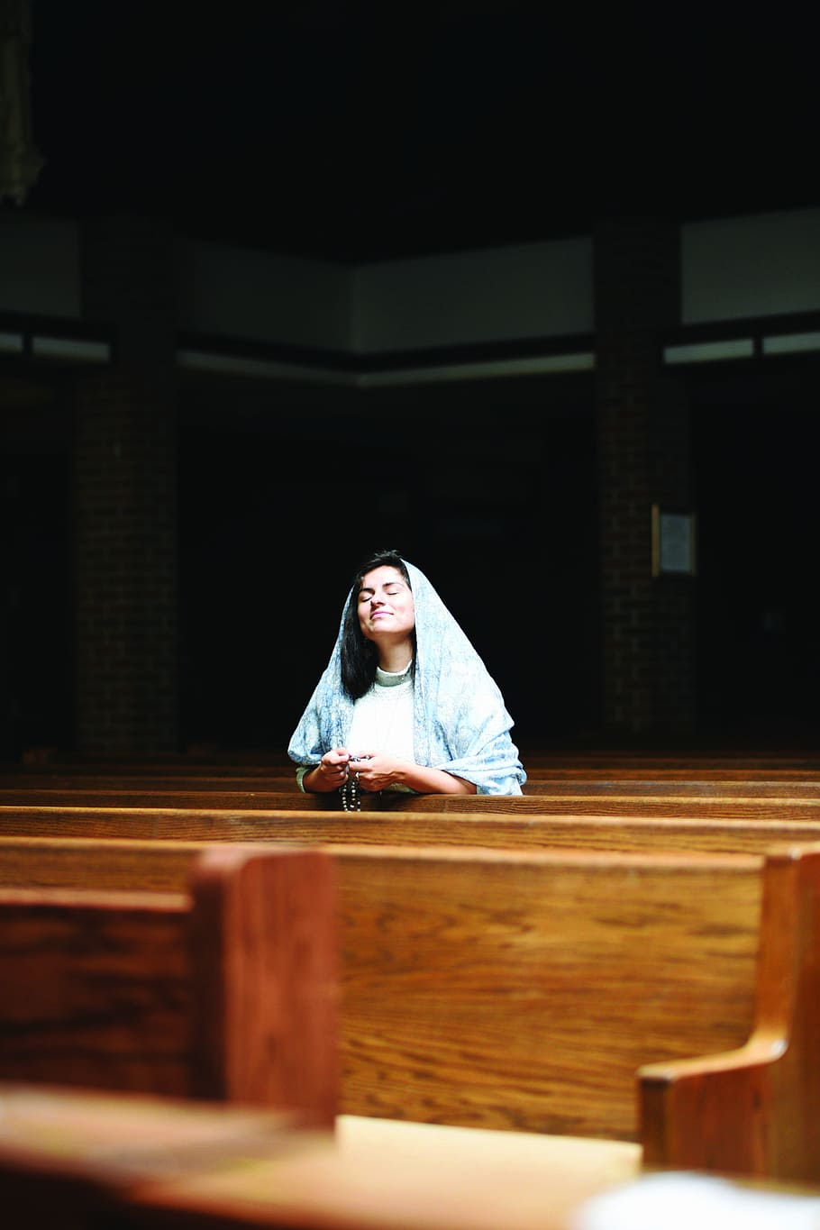 woman holding rosary, woman praying inside church, person, seat
