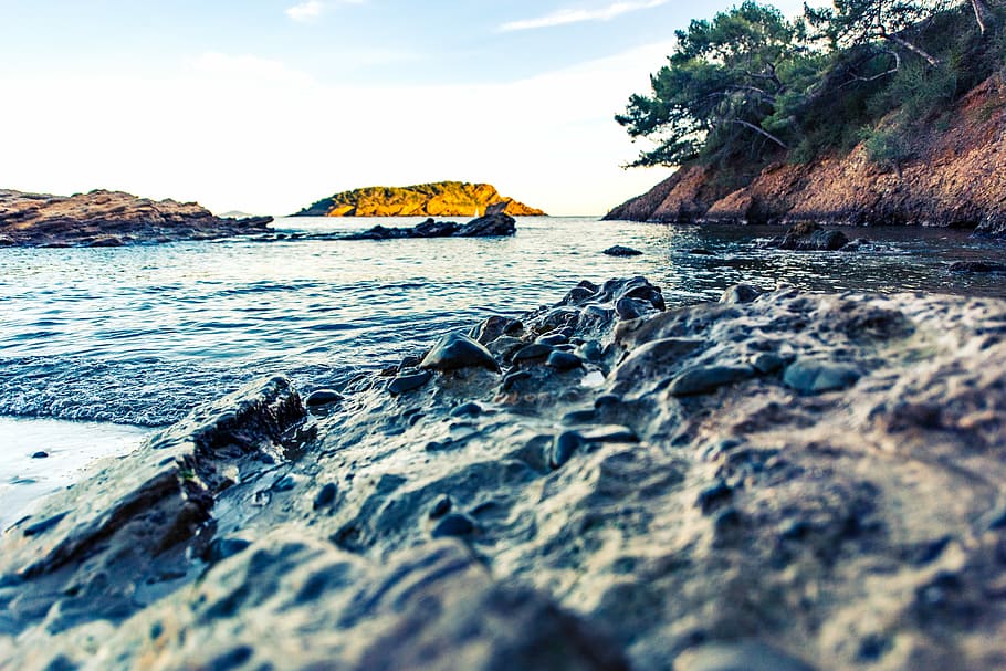 rocks beside body of water and mountains at daytime, rock formation near body of water HD wallpaper