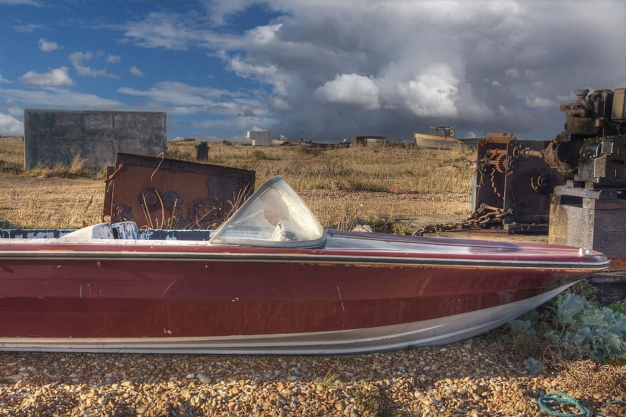 An old abandoned speed boat sits on the shingle beach at Dungeness, Kent, England, HD wallpaper