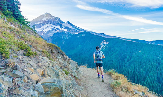 man running on edge near mountain, man running on cliff under clear blue sky HD wallpaper