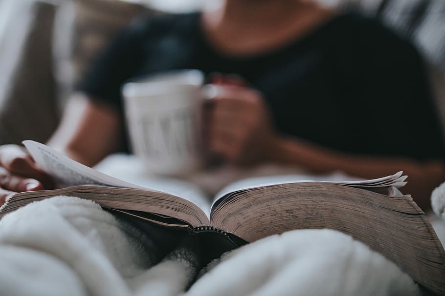 person holding coffee mug, man holding white ceramic mug while reading book HD wallpaper