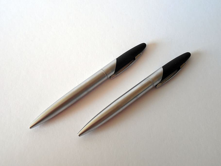 two silver-and-black retractable pens on white surface, leave HD wallpaper