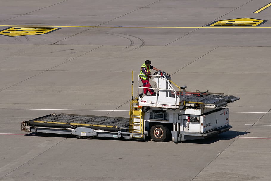 man riding on airplane ladder, special-purpose vehicle, airport